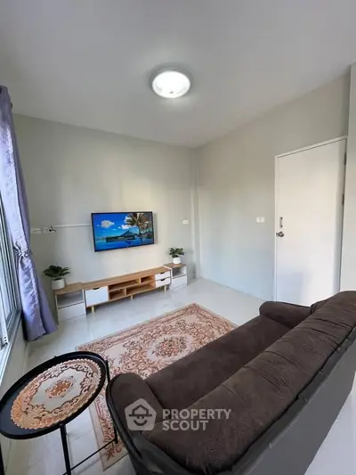 Cozy living room with modern decor, plush sofa, and wall-mounted TV, perfect for relaxation.