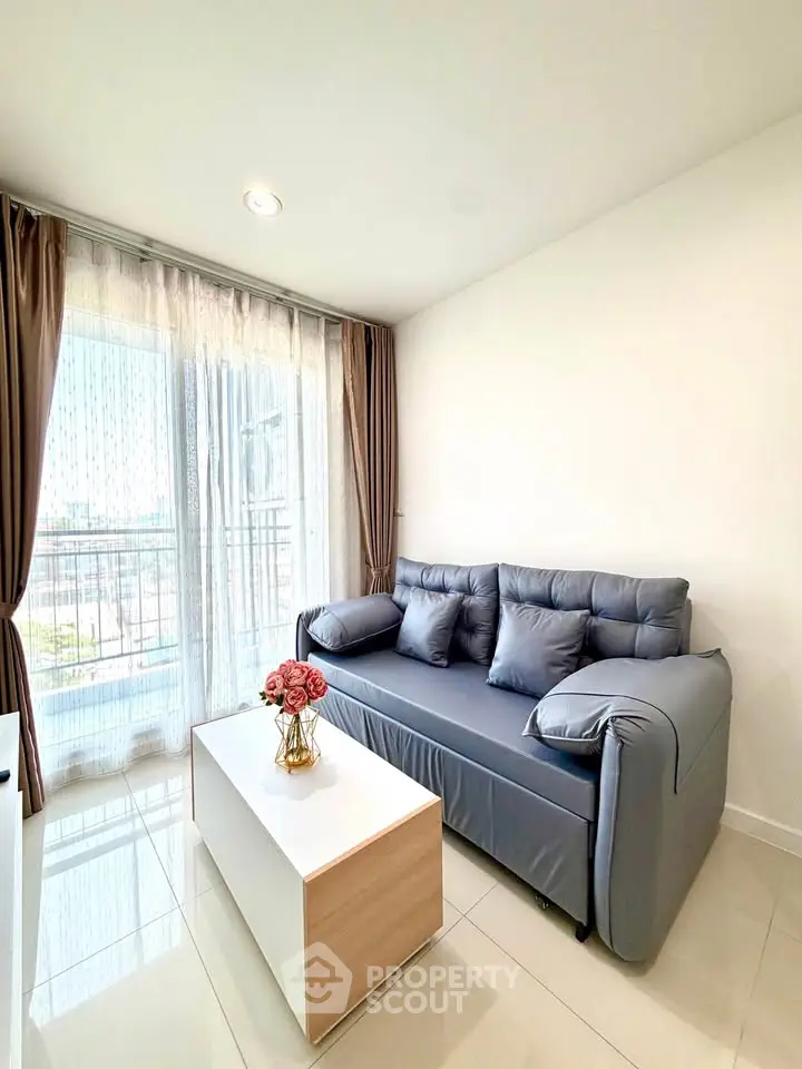 Modern living room with stylish sofa and natural light from large window.