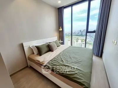 Modern bedroom with large window offering stunning city view