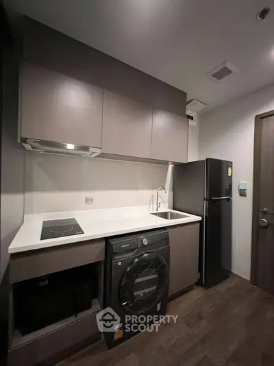 Modern kitchen with sleek cabinetry, built-in appliances, and stylish flooring in a compact layout.
