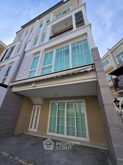 Modern multi-story building with elegant facade and large windows in urban setting.