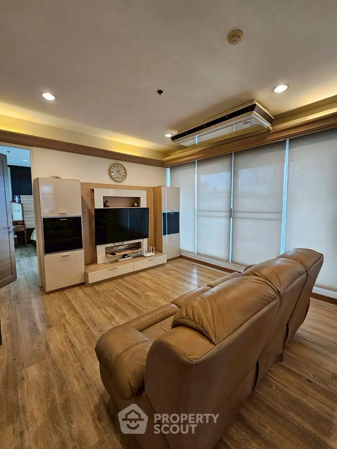 Spacious living room with modern decor and large windows in a stylish apartment.