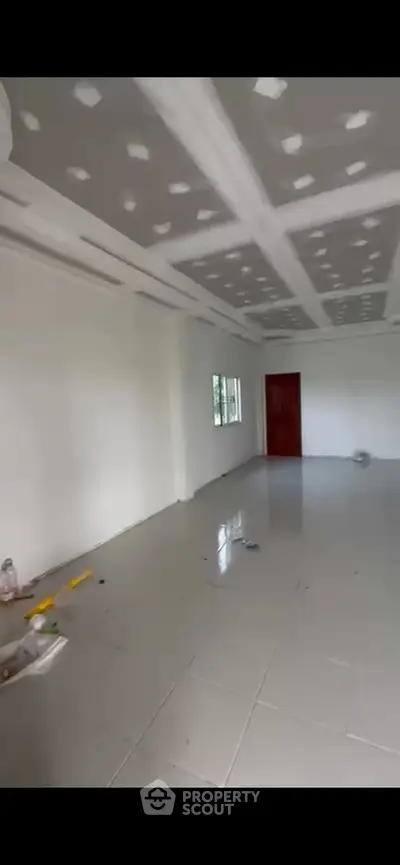 Spacious empty room with tiled floor and modern ceiling design