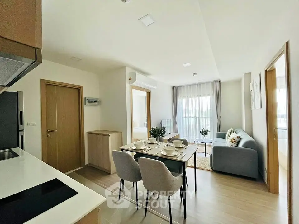 Modern open-plan living room and kitchen with elegant dining setup and cozy seating area.