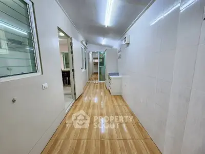 Spacious hallway with modern tile flooring and bright lighting in a contemporary home.