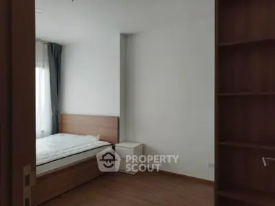 Spacious bedroom with wooden flooring and natural light