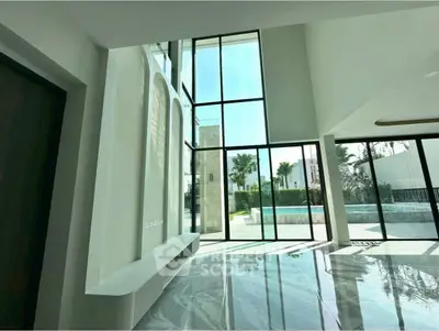 Spacious modern living room with floor-to-ceiling windows and pool view