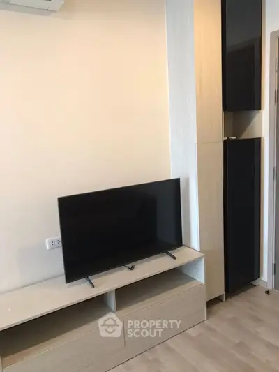 Modern living room with sleek TV setup and stylish storage solutions.