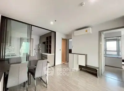 Modern open-plan living and dining area with sleek furniture and air conditioning.