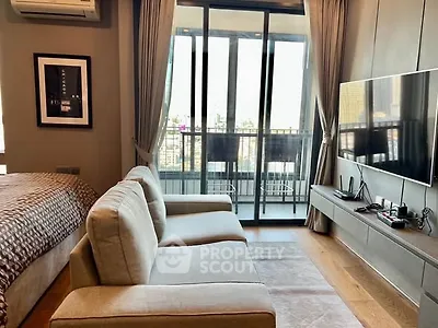 Modern living room with balcony view, sleek furniture, and large TV setup.