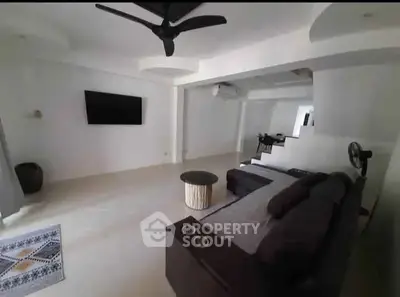 Spacious modern living room with sleek design and ceiling fan