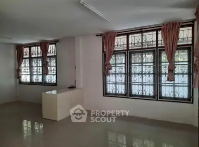 Spacious living room with large windows and elegant curtains in a modern home.