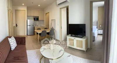 Modern open-plan living room with stylish furniture and kitchen area in a cozy apartment.