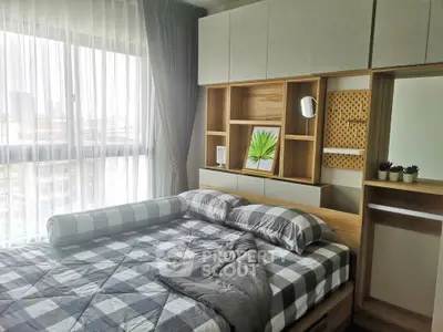 Modern bedroom with stylish decor and large window offering natural light