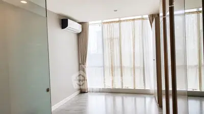 Spacious modern living room with large windows and air conditioning