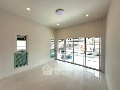 Spacious living room with large windows and natural light in modern home.