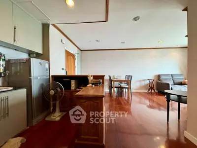 Spacious living room with wooden flooring and modern kitchen area