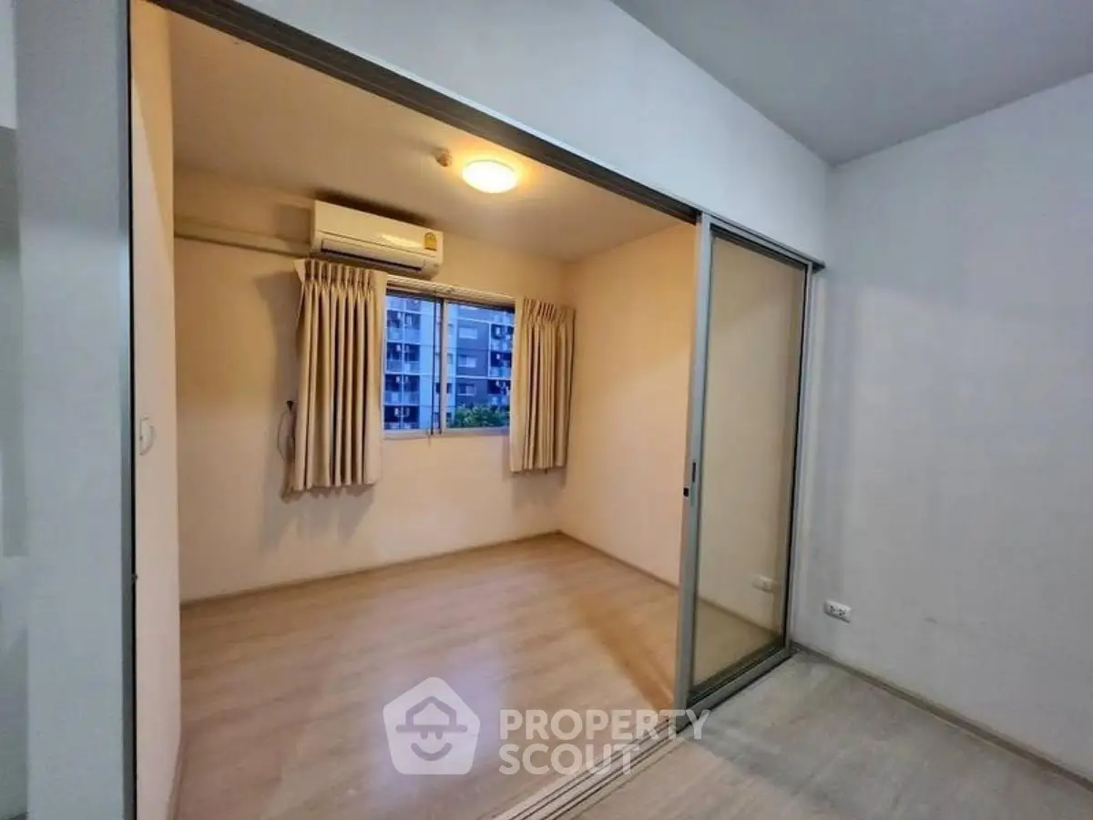 Cozy small room with sliding glass doors and air conditioning, perfect for a study or compact bedroom.