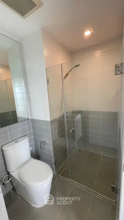 Modern bathroom with glass shower enclosure and sleek tile design