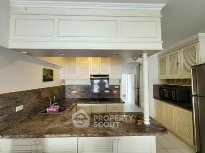 Spacious kitchen with elegant granite countertops and modern appliances