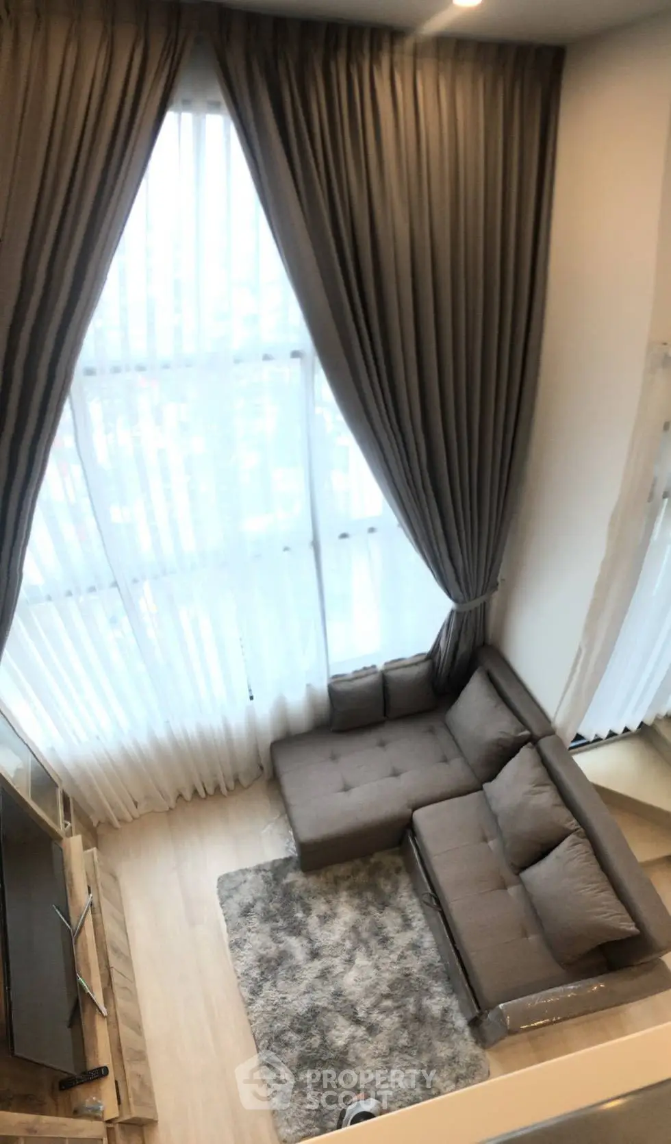 Luxurious high-ceiling living room with elegant curtains and cozy sectional sofa