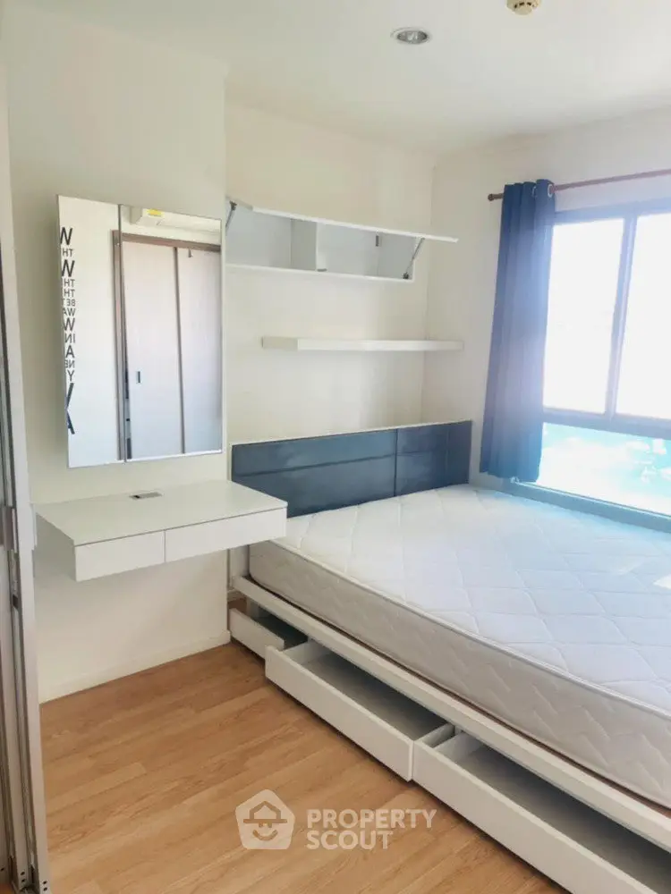 Modern bedroom with natural light, sleek furniture, and hardwood floors in a stylish apartment.