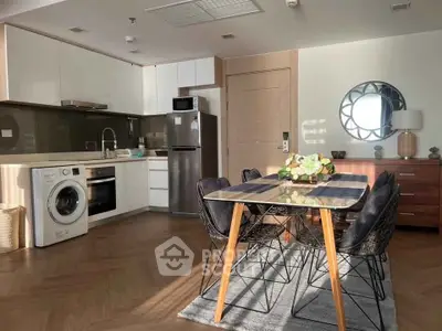 Modern kitchen with dining area, featuring sleek appliances and stylish decor.