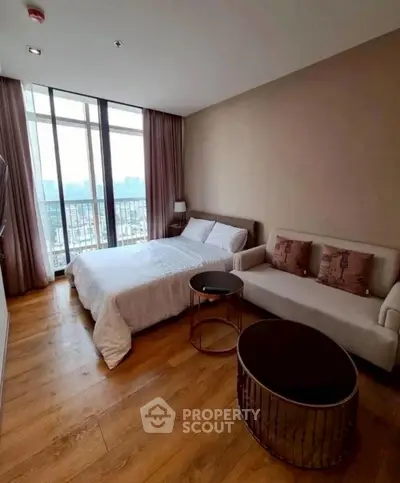 Modern bedroom with city view, featuring cozy bed and stylish sofa.
