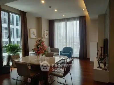 Elegant living room with modern furniture and large windows offering city views.
