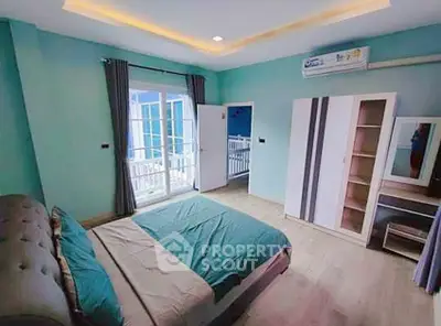 Spacious bedroom with modern decor and balcony access in a stylish home.