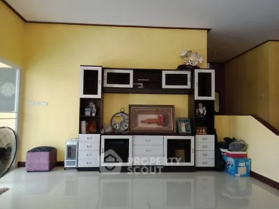 Spacious living room with modern entertainment center and bright yellow walls
