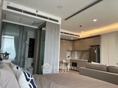 Modern open-plan studio with stylish kitchen and cozy living area, featuring sleek design and ample natural light.