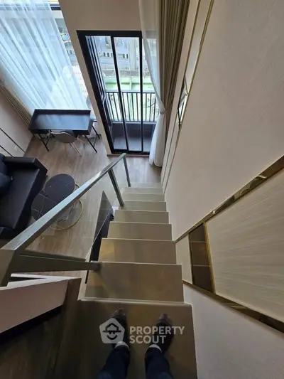 Modern loft apartment with mezzanine stairs and balcony view, featuring sleek interior design and natural light.
