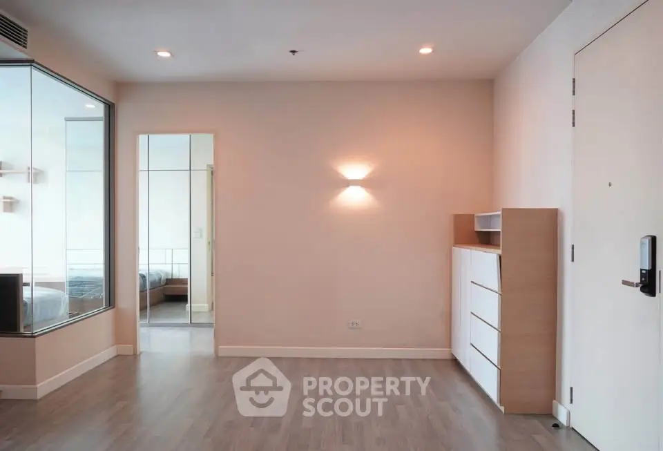 Spacious modern apartment interior with sleek wooden flooring and stylish lighting, perfect for urban living.
