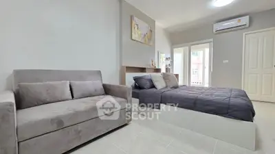 Modern bedroom with cozy sofa and stylish decor in a bright apartment.