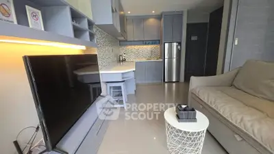 Modern living room with sleek kitchen, cozy sofa, and stylish decor in a contemporary apartment.
