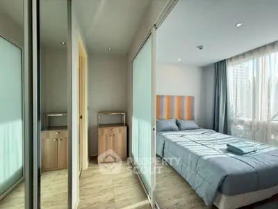 Modern bedroom with large windows and sliding closet doors, featuring natural light and cozy decor.