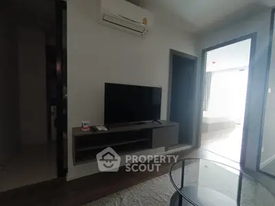 Modern living room with sleek TV setup and air conditioning, leading to a bright bedroom.
