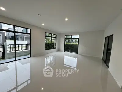 Spacious modern living room with large windows and glossy tiled floors