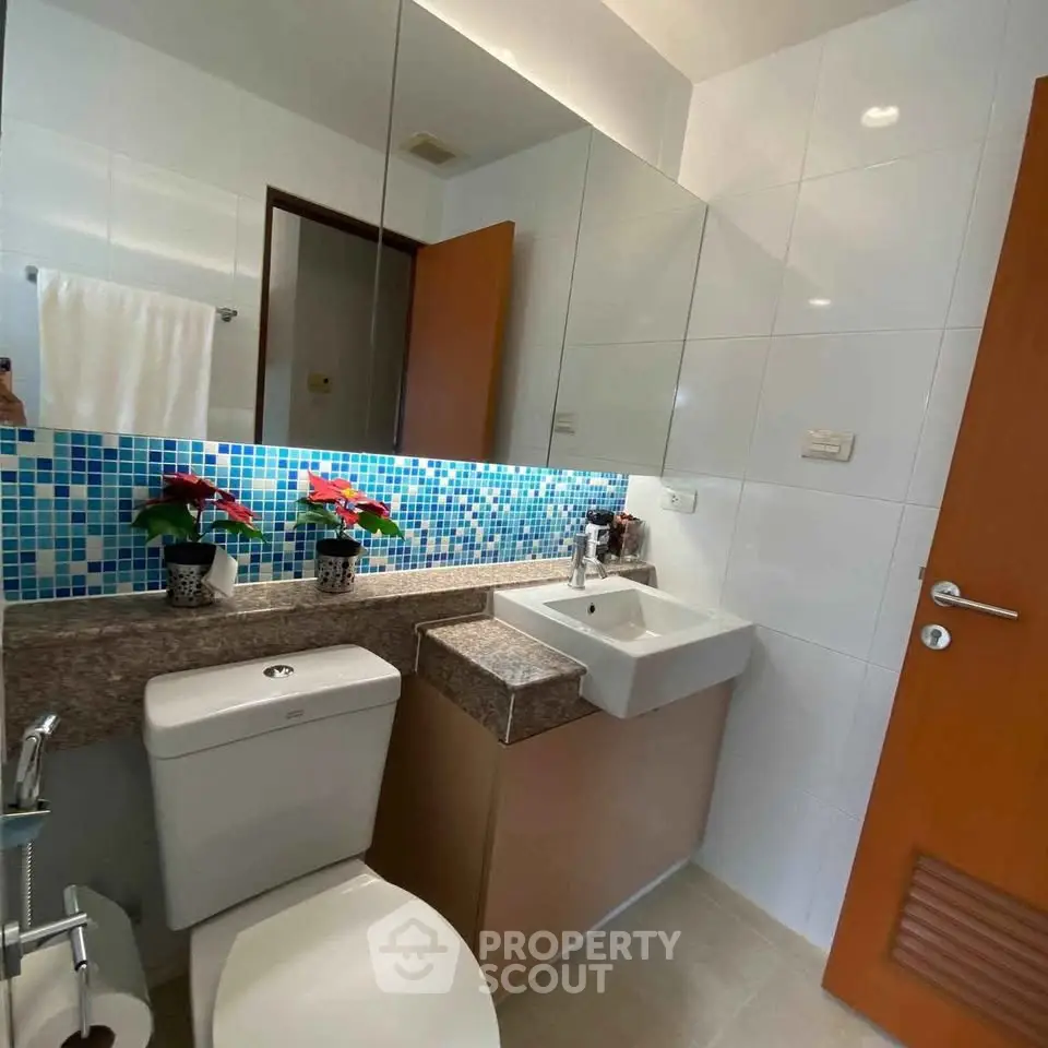 Modern bathroom with stylish mosaic tiles and sleek fixtures in a contemporary apartment.