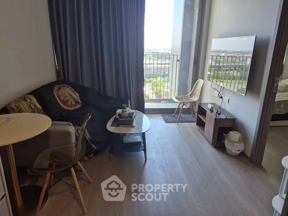 Modern living room with balcony view, stylish furniture, and natural light.