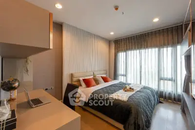 Modern bedroom with large window and stylish decor in a luxury apartment.