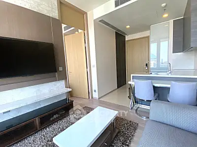 Modern living room with sleek furniture and open kitchen layout in a stylish apartment.