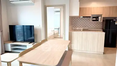Modern open-plan living room and kitchen with stylish decor and natural light.