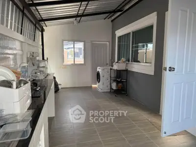 Modern kitchen with gas stove and washing machine in sleek open layout