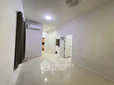 Spacious unfurnished room with air conditioning and glossy tiled floor.