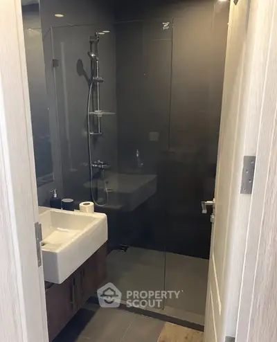 Modern bathroom with sleek glass shower and stylish sink in contemporary home.