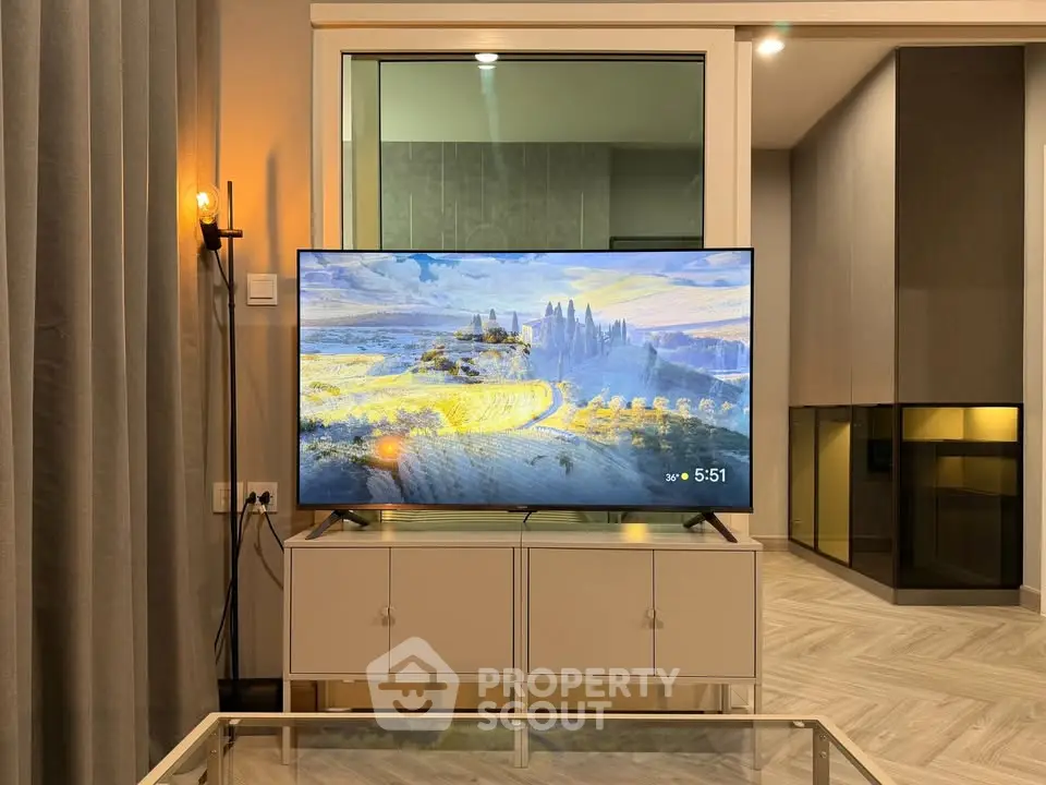 Modern living room with stylish decor and large flat-screen TV, perfect for entertainment and relaxation.