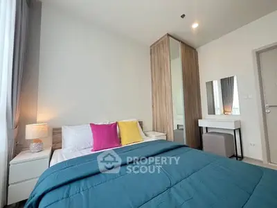 Modern bedroom with stylish decor and cozy bedding in a bright apartment.