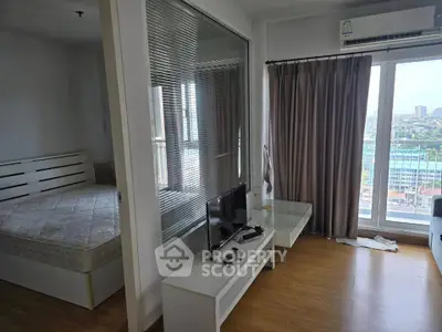 Modern apartment with bedroom and living area, featuring large windows and city view.
